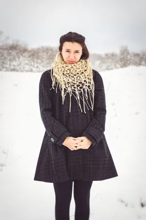 Smiling model in winter cloak on snowy day