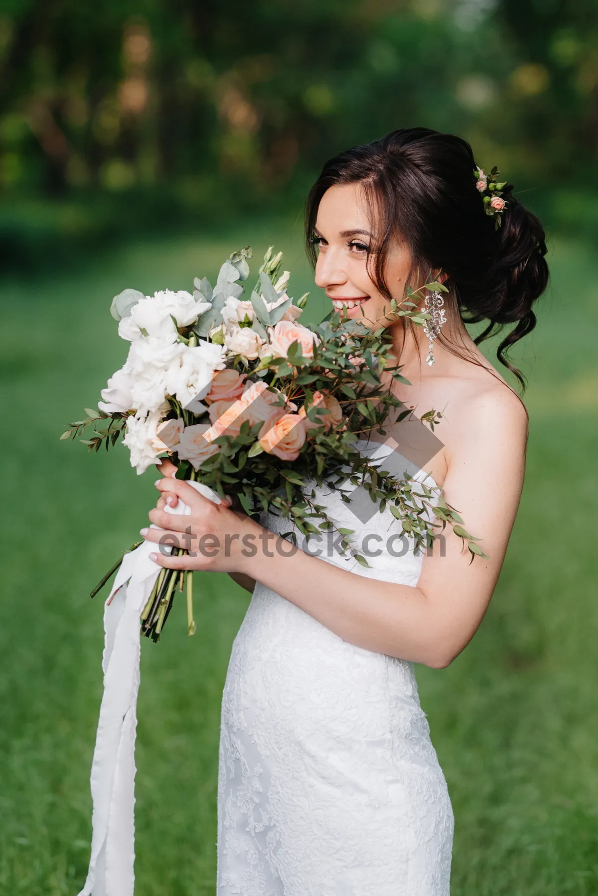 Picture of Smiling Bride and Groom with Flower Bouquet in Garden