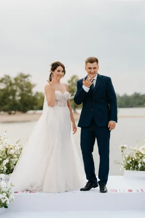 Happy newlywed couple celebrating wedding day outdoors.