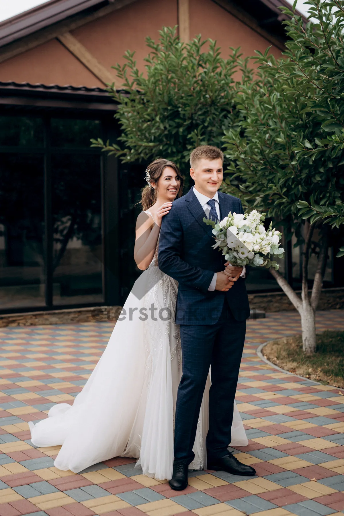 Picture of Happy married couple celebrating wedding outdoors with flowers