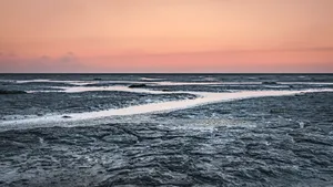 Tropical sunset over tranquil beach shoreline landscape.