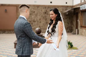 Happy couple in wedding attire holding bouquet.