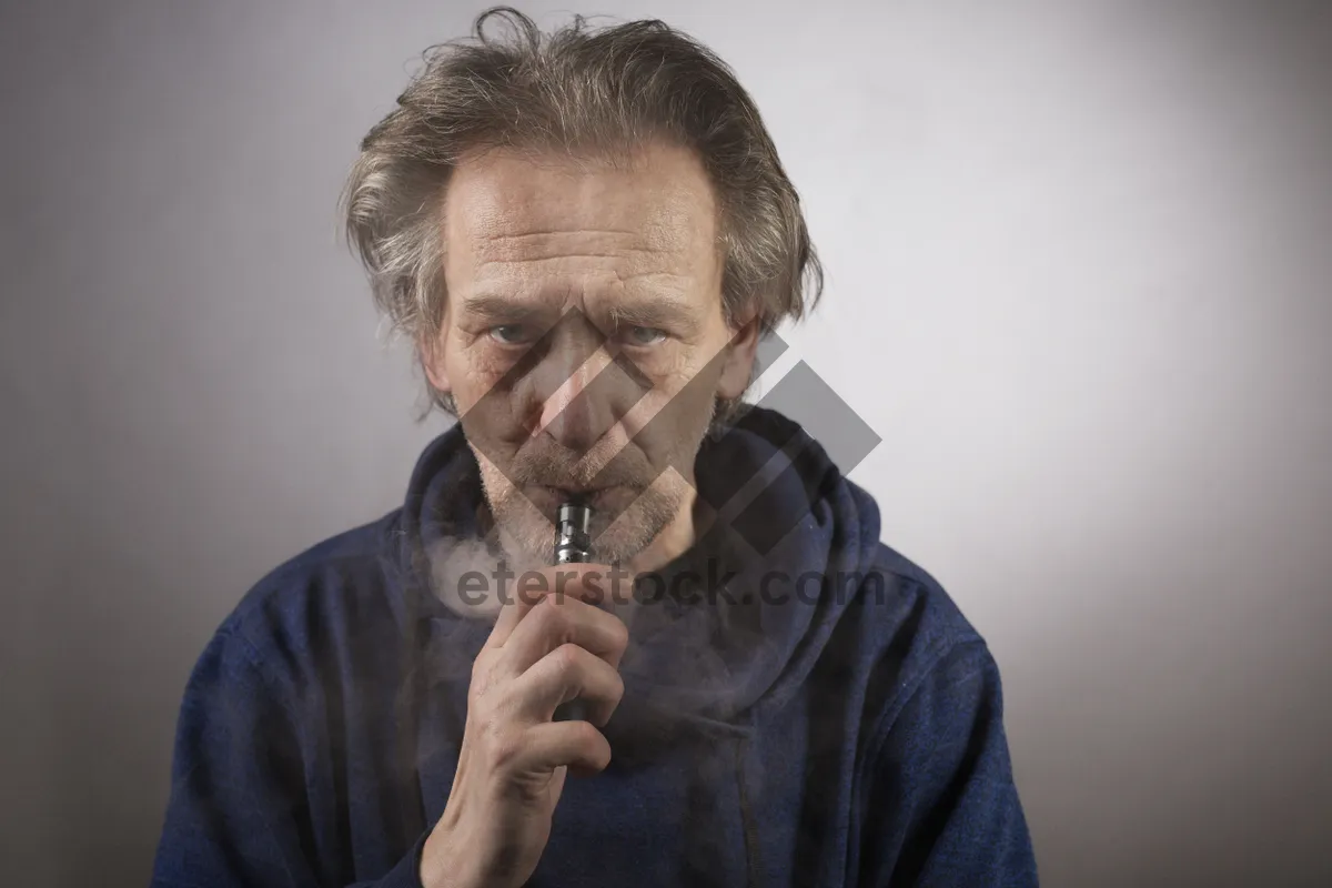 Picture of Senior man playing harmonica outdoors in the wind