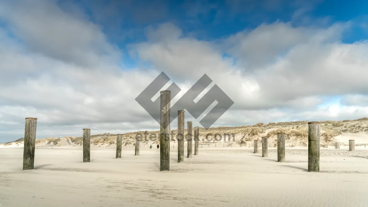 Picture of Beach Pier Under Cloudy Sky by the Ocean