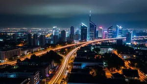 Twilight skyline of modern city with steel arch bridge.