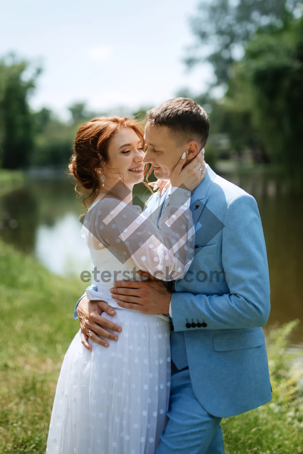 Picture of Happy couple in park on wedding day smiling joyfully.