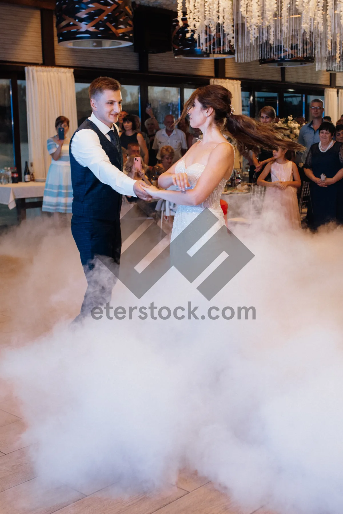 Picture of Stylish model in wedding dress dances happily at wedding.